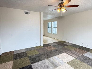 Spare room featuring ceiling fan, a textured ceil