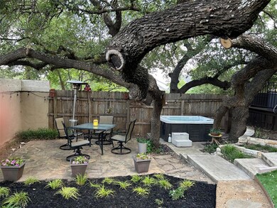Fenced backyard featuring a hot tub, a patio, and