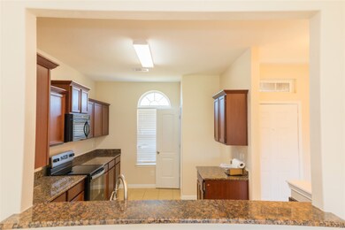 This kitchen features dark granite countertops, ri