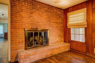 Unfurnished living room featuring wood walls, a fi