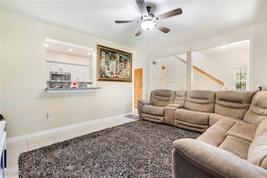 Living room featuring light tile patterned floors, a ceiling fan, and recessed lighting