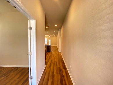 Hall with dark wood finished floors, recessed lig