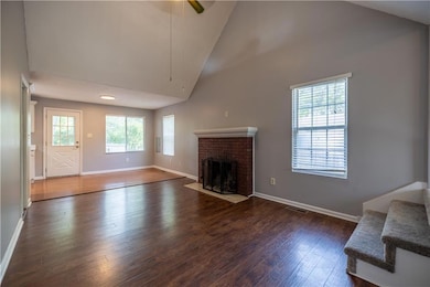 Great room with vaulted ceiling, ceiling fan and fireplace