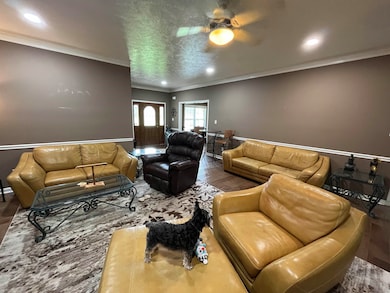 Living room featuring ceiling fan, hardwood / wood