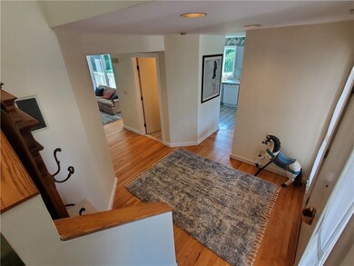 Foyer view from stairs to living room, half bath, kitchen and front door.