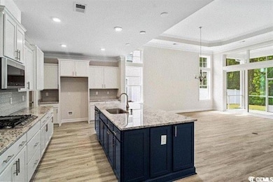 Kitchen with white cabinetry, light wood-type floo