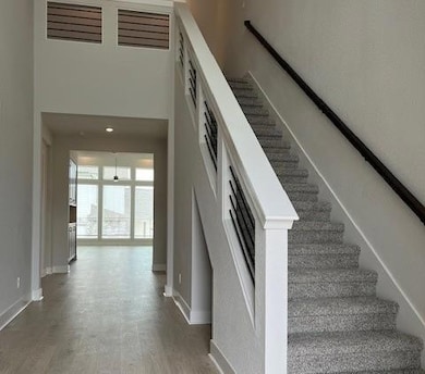 Stairway featuring wood finished floors, baseboar