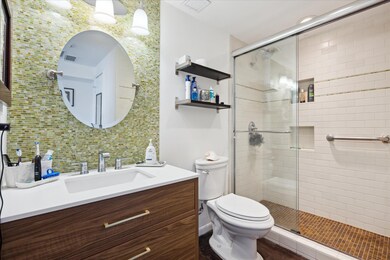 Bathroom featuring vanity, a stall shower, and ta