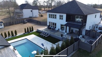 Back of house featuring a fenced in pool, a balcon