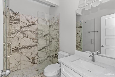 Full bathroom featuring toilet, vanity, and a stall shower