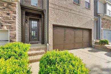 Doorway to property with concrete driveway and bri