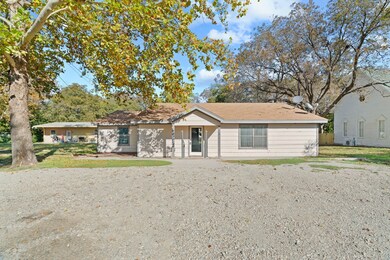 Single story home with gravel driveway and a front yard