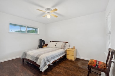 Bedroom with wood finished floors, baseboards, an