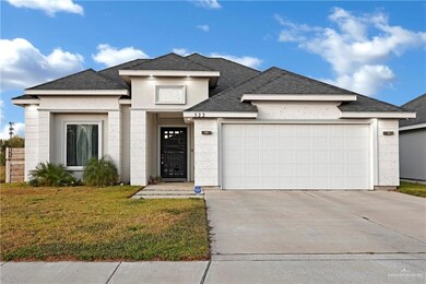 View of front of property featuring a garage and a front yard