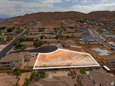 Aerial view of residential area featuring property boundaries highlighted and a mountainous background