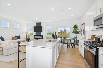 (Photo of decorated model, actual home's finishes will vary) An open layout flows from the Kitchen to the dining room to the great room with ease.