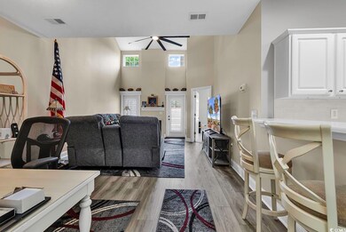 Living room with a towering ceiling, hardwood / wo