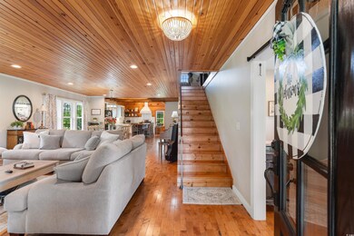 Living area featuring stairs, wooden ceiling, light wood finished floors, recessed lighting, and a chandelier