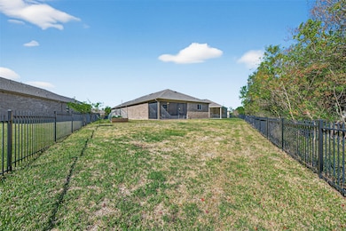 Highly sought after large private lot! No rear neighbors. The yard is enclosed with a black metal fence, offering privacy and security. The area is surrounded by lush trees, providing a serene and natural setting.