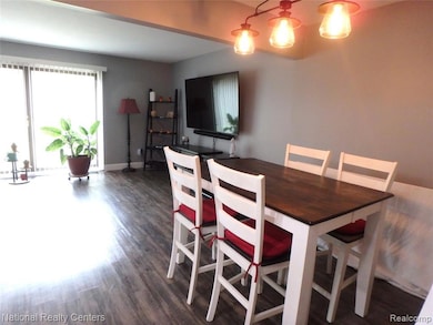 Dining room with dark wood-type flooring and baseboards