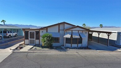 View of front facade with a mountain view, a sunroom, and a carport