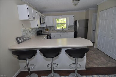 Kitchen with breakfast bar, laundry hookup behind closet doors to right