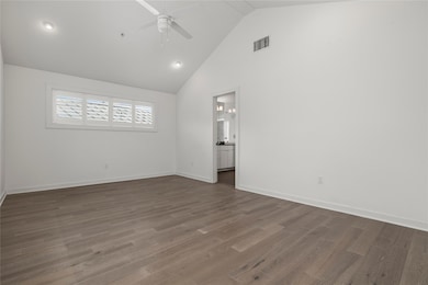 Empty room featuring a ceiling fan, high vaulted 
