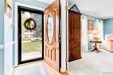 Carpeted entrance foyer with ornamental molding. B
