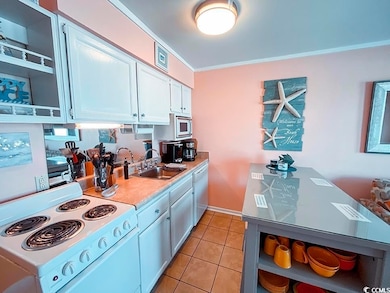 Kitchen featuring open shelves, a sink, light coun