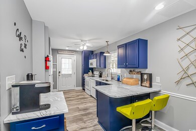 Kitchen featuring sink, white appliances, blue cab