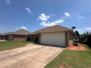 Ranch-style house featuring brick siding, an attached garage, driveway, a front lawn, and central air condition unit