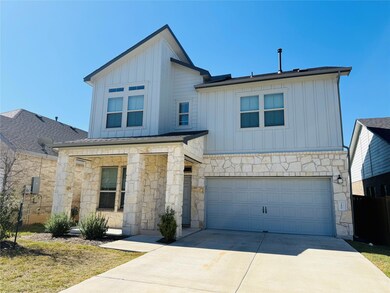 View of front of home with board and batten siding, stone siding, a garage, and concrete driveway