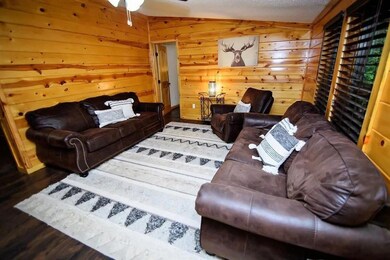 Living room featuring ceiling fan, wood finished f