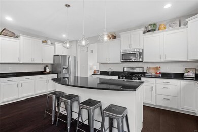 Endless staggered cabinets topped with crown molding, a walk-in pantry, and a breakfast bar island!