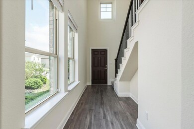 Foyer entrance with baseboards, a high ceiling, d