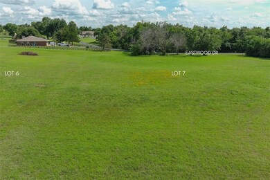 View of green lawn featuring view of wooded area