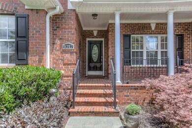 Inviting Entrance with wrought iron rails, brick pavers, leaded glass door.