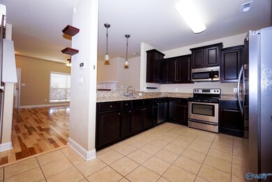 Stainless appliances, Espresso wood cabinetry and beautiful granite countertops. Home has new oversized water heater. Kitchen has bar and is open to dining room, living area and covered back porch overlooking huge yard with fruit trees.