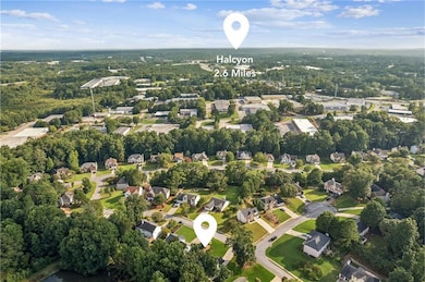 Aerial view of property's location with nearby suburban area and a tree filled landscape