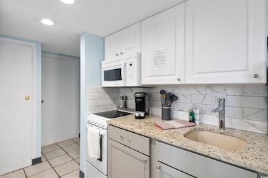 Kitchen featuring white cabinetry, white appliance