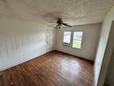 Empty room with wood walls, ceiling fan, and dark 