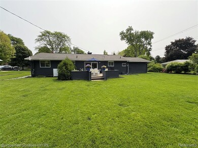 Back of house featuring a wooden deck, a yard, and outdoor lounge area