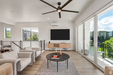 Living area featuring light wood-style floors, recessed lighting, and a ceiling fan
