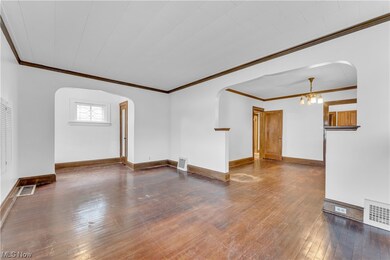 Unfurnished room with an inviting chandelier, dark hardwood / wood-style floors, and ornamental molding