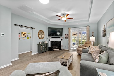 Living area with a tray ceiling, baseboards, visib