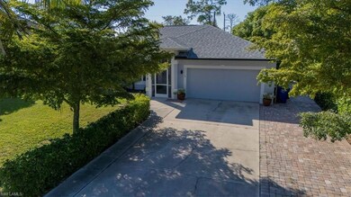 View of front facade with a front yard, a shingled roof, driveway, a garage, and stucco siding