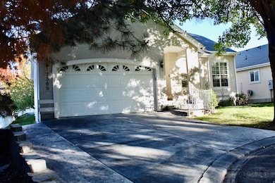 Single story home featuring concrete driveway, stucco siding, an attached garage, a front yard, and roof with shingles