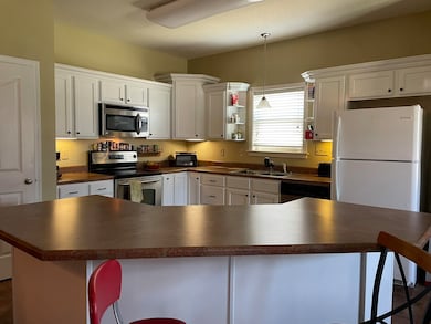 Kitchen featuring dark countertops, appliances wit