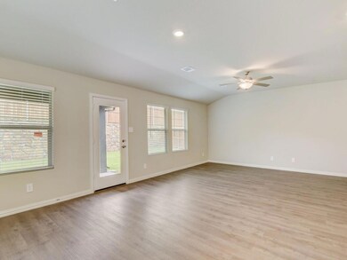 Spare room with ceiling fan, vaulted ceiling, and light wood-type flooring