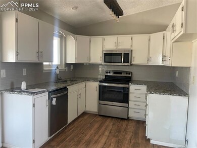 Kitchen features updated cabinetry, granite counte